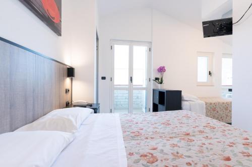 A bed or beds in a room at Hotel Saint Tropez - Pineto