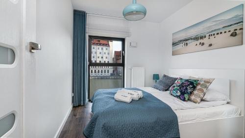 sypialnia z łóżkiem i dużym oknem w obiekcie Leopold Winter Residence - BillBerry Apartments w Gdańsku