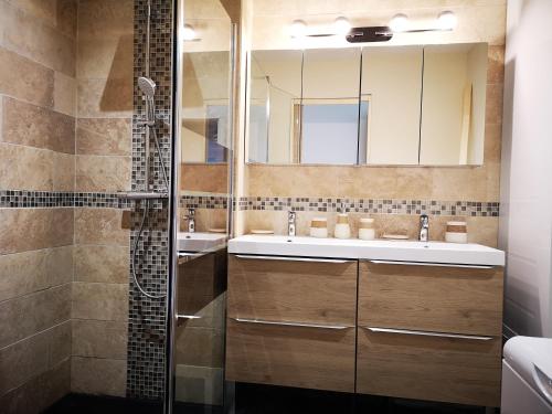 ein Badezimmer mit zwei Waschbecken und einer Dusche in der Unterkunft Les Terrasses de l'Océan in Mimizan