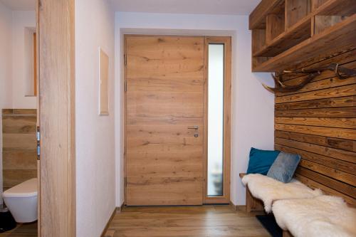 a room with a wooden door and a toilet at Appartement Enzian & Mark in Ellmau