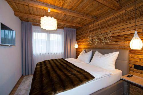 a bedroom with a large bed with a wooden ceiling at Appartement Enzian & Mark in Ellmau