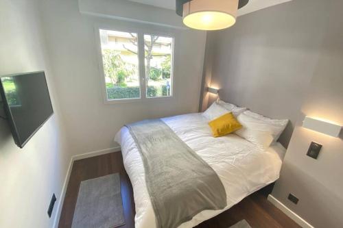 Dormitorio pequeño con cama con almohada amarilla en Renovated 2 bedrooms 50m from the Croisette and the sea, en Cannes