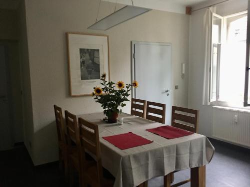 a dining room table with a vase of flowers on it at HERBERGE 28 Ferienwohnung für bis zu 6 Personen in Saalfeld