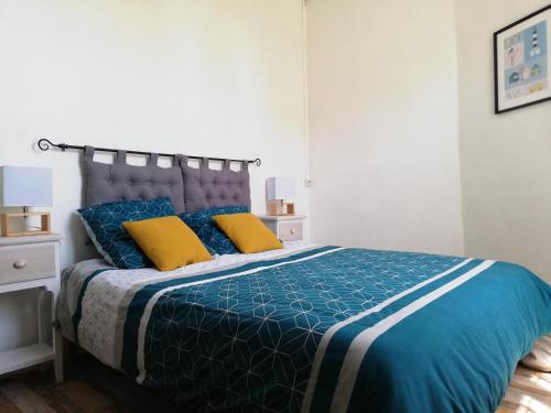 a bedroom with a bed with blue and yellow pillows at La Marinière, 3chb, à 500m de la mer - St Denis Oléron in La Gautrie