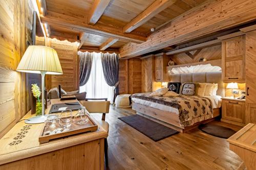 a bedroom with a bed and a desk at Fiocco di Neve Relais & SPA in Limone Piemonte