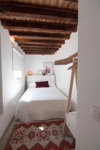 a bedroom with a white bed and a wooden ceiling at Gardina Toledo in Toledo