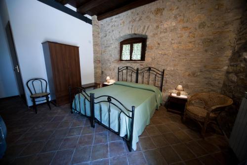 a bedroom with a bed and a brick wall at Agriturismo Sant'Agata in Piana degli Albanesi