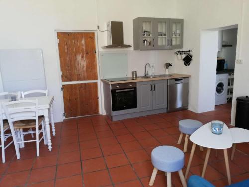 a kitchen with a table and some chairs and a counter at La Marinière, 3chb, à 500m de la mer - St Denis Oléron in La Gautrie