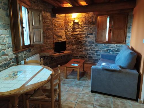 a living room with a table and a blue couch at Apartamentos Borda Falceto in Coscojuela de Sobrarbe