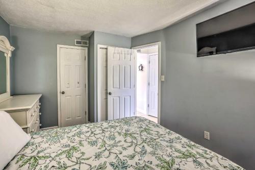 a bedroom with a bed with a floral bedspread at 1 Block to Ocean Shore Condo in Myrtle Beach! in Myrtle Beach