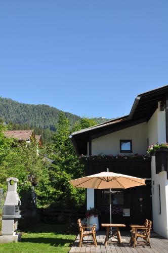 a patio with a table and an umbrella at Landhaus Zirben in Bad Kleinkirchheim