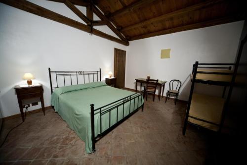 a bedroom with a bed and a table and chairs at Agriturismo Sant'Agata in Piana degli Albanesi