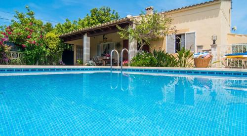 a swimming pool in front of a house at Finca con piscina Es Baladre in Capdepera