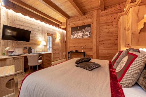a bedroom with a bed in a room with wooden walls at Fiocco di Neve Relais & SPA in Limone Piemonte
