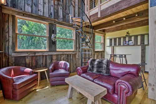 a living room with leather furniture and wooden walls at Red Sweetheart Barn Studio with Mtn and River Views! in Westminster