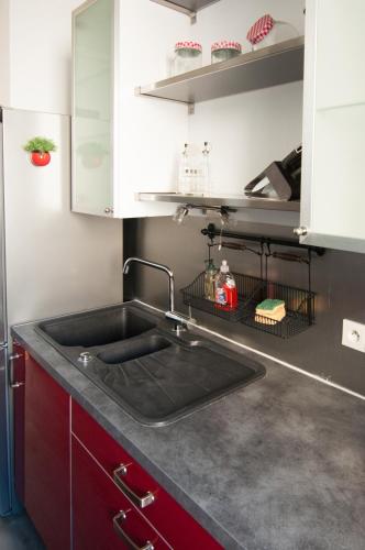 - une cuisine avec un évier et des placards rouges dans l'établissement Bel appartement Tours Centre 2 chambres, 6 pers 