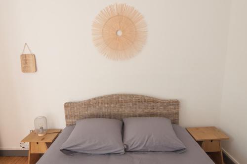 a bedroom with a bed with a rattan headboard and two tables at Bel appartement Tours Centre 2 chambres, 6 pers "Pied-à-Tours" in Tours