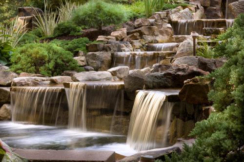 a waterfall in a garden with rocks and trees at Hyatt Regency Suites Atlanta Northwest in Atlanta