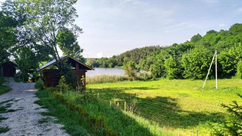 a smallshed in a field next to a body of water at Zelenaya Usad`ba StavBor in Zavadivka