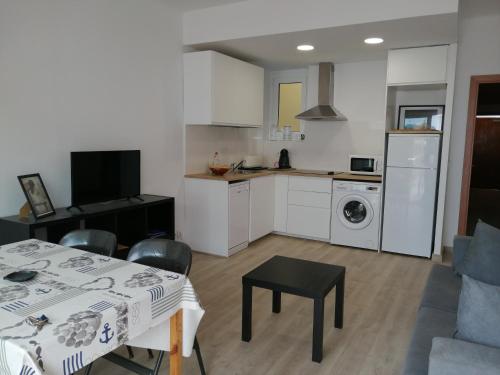 cocina y sala de estar con mesa y comedor en Apartament Passeig Maritim en Llança