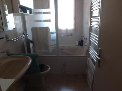 une salle de bain avec une baignoire, un lavabo et des toilettes dans l'établissement T3 très agréable, 2 terrasses, bien placé, à Amélie-les-Bains-Palalda