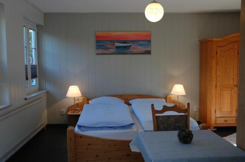 a bedroom with a bed and a table and two lamps at Hotel Kappelner Hof in Kappeln