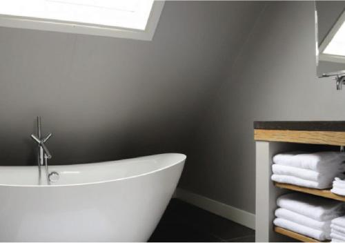 a white bath tub in a bathroom with towels at Bed & Breakfast Bennekom in Bennekom