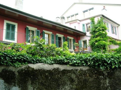 a red house with green shuttered windows and plants at Lac et Mont-Blanc in Nyon