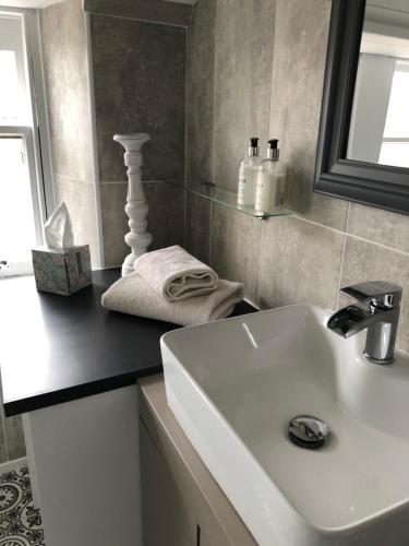 a bathroom with a white sink and a mirror at Thistle Apartment, Inverness in Inverness