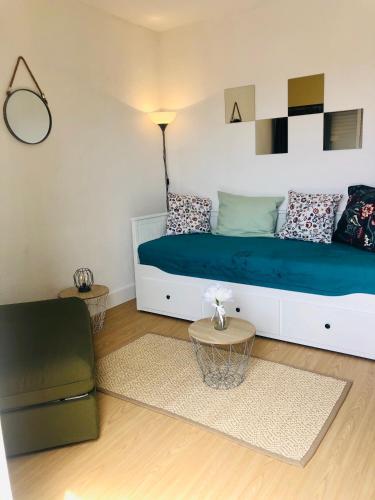 - une chambre avec un lit bleu et une chaise dans l'établissement Studio Nefs des Sables, à Leucate
