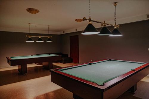a living room with two pool tables and lights at Panorama_SPA in Trzęsacz