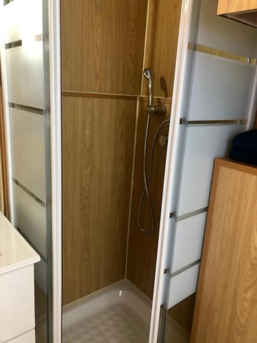 une douche avec une porte vitrée dans une salle de bain dans l'établissement Studio Nefs des Sables, à Leucate