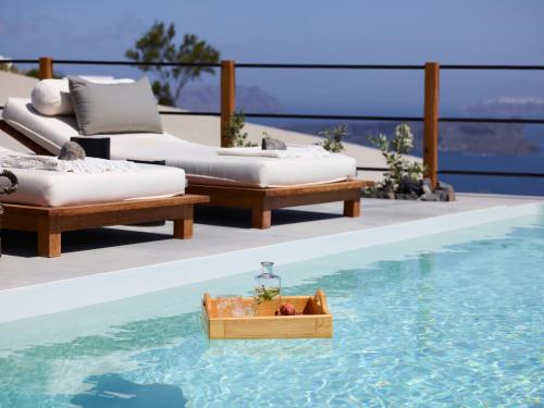 a tray of food in the water next to a swimming pool at Melidonia Suites in Akrotiri