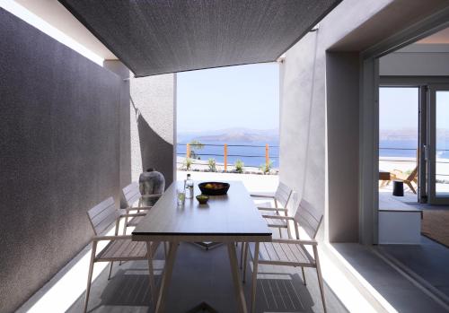 a dining room with a table and chairs on a balcony at Melidonia Suites in Akrotiri
