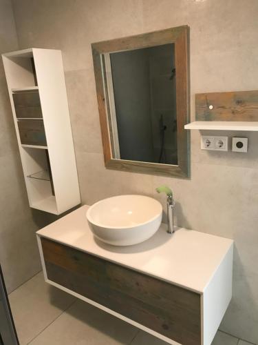 a bathroom with a white sink and a mirror at Portorož Apartments in Portorož