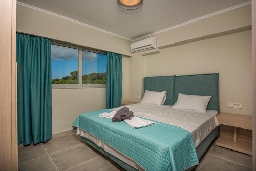 a bedroom with a bed with blue curtains and a window at Metsovo Big Apts in Laganas
