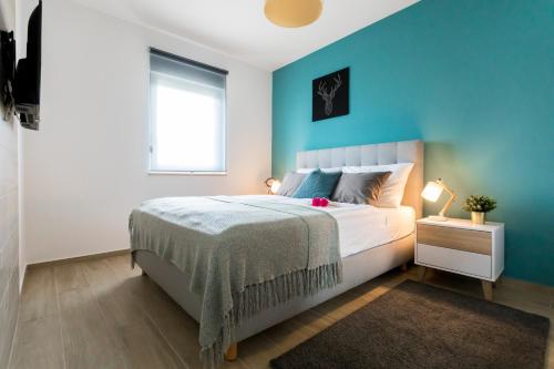 sypialnia z łóżkiem i niebieską ścianą w obiekcie Apartments Villa Fe w mieście Malinska