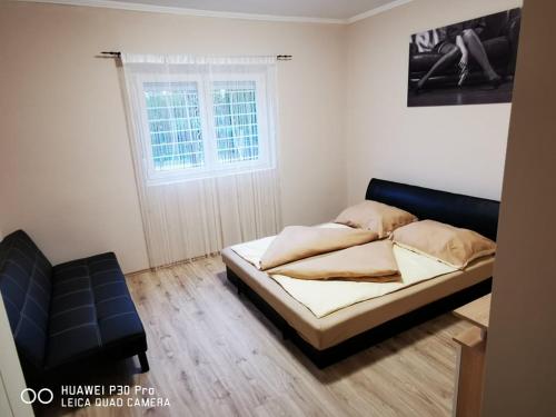 a bedroom with a bed and a window at Renáta Apartman in Siófok