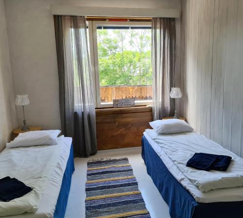 Duas camas num quarto com uma janela em Saltvik Bed & Breakfast em Saltvik
