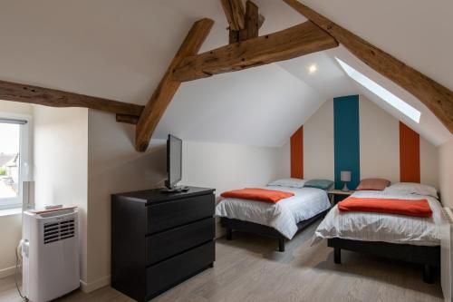 Un dormitorio con dos camas y un televisor. en Gîtes à côté de Chambord, Blois, Cheverny, en Saint-Claude-de-Diray