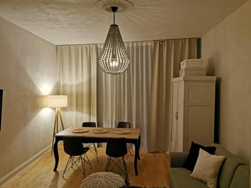 a living room with a table and chairs and a chandelier at Quedlinburg Marktplatz-Suites in Quedlinburg
