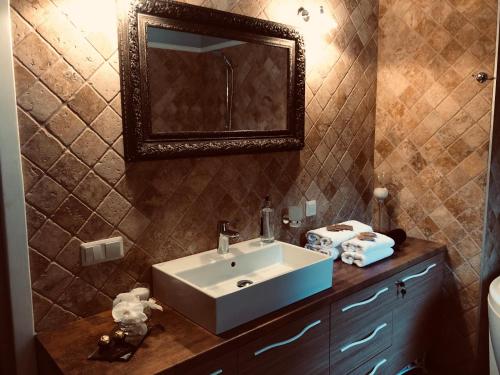 uma casa de banho com um lavatório e um espelho em Villa Valery - pajūrio dvasia dvelkianti oazė em Kupriai