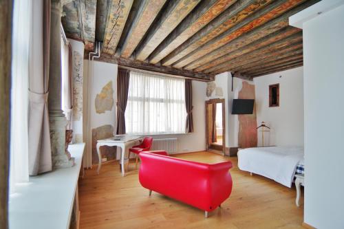 una camera con una sedia rossa e un letto di Hotel Regent Tallinn a Tallinn