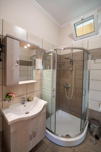 a bathroom with a glass shower and a sink at Villa Nektaria in Nikiana