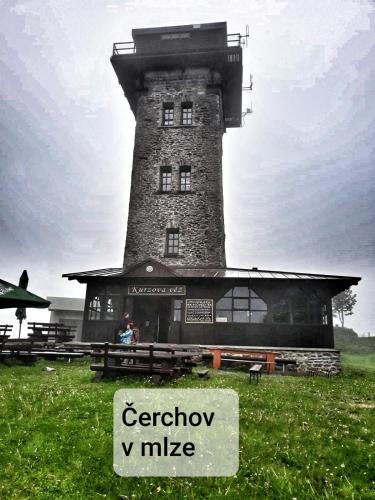 a building with a tower with a sign in front of it at Dřevěný prázdninový domek SUNRISE in Stará Huť