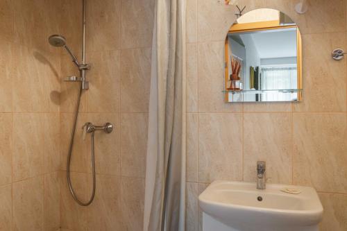 y baño con ducha, aseo y lavamanos. en Family-friendly 2 rooms apartment with view to a forest, en Juodkrantė