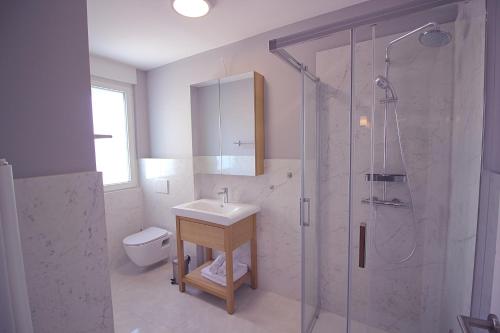 a bathroom with a shower and a sink and a toilet at Sun Apartments in Primošten