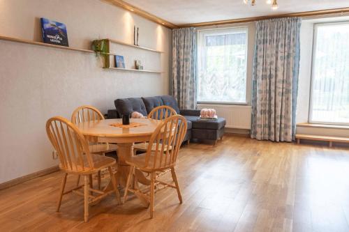 a living room with a table and chairs and a couch at Cozy one room apartment with yard in Juodkrantė