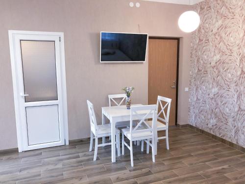a dining room with a table and chairs and a television at Marsas in Zarasai
