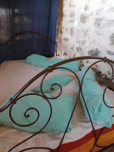 a bed with a metal bed frame and pillows at Nid de Poussins in Vaumeilh